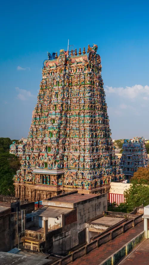 Intricately carved gopuram of Meenakshi Amman Temple in Madurai, Tamil Nadu, showcasing vibrant Dravidian architecture, a historic landmark featured in Tamil Nadu tour packages.