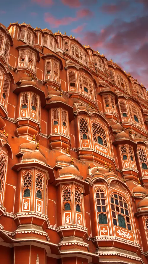 Intricate pink sandstone facade of Hawa Mahal in Jaipur Rajasthan featuring ornate jharokha windows and Rajput architecture included in Rajasthan tour packages