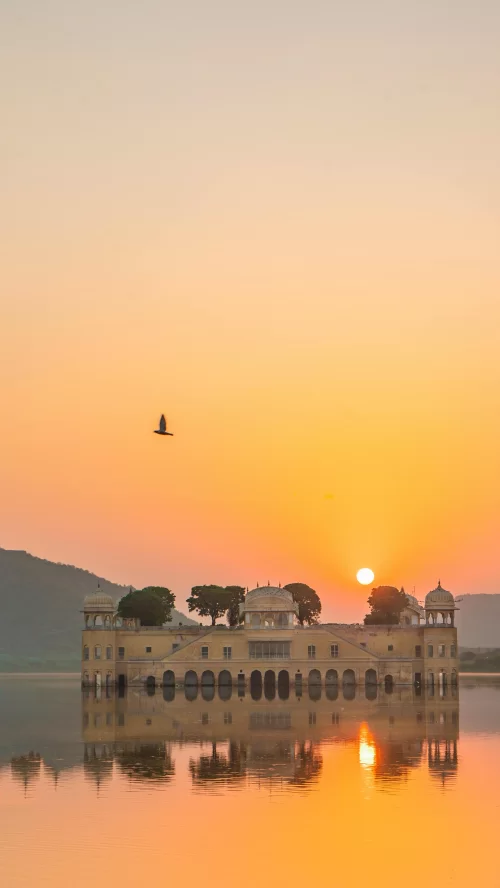 Sunset view of Jal Mahal in Jaipur Rajasthan with golden sky reflection on Man Sagar Lake creating a serene royal landscape included in Rajasthan tour packages