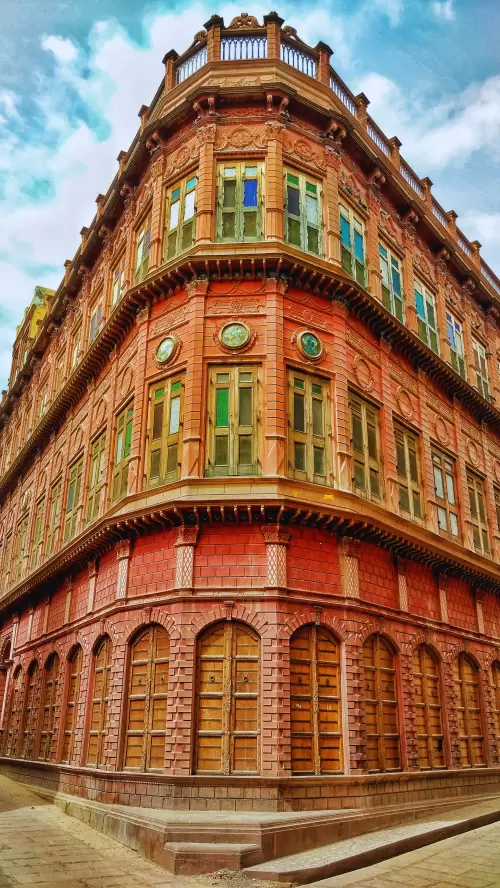 Ornate red sandstone facade of Rampuria Haveli in Bikaner Rajasthan featuring intricate jharokha windows and Rajput architecture included in Rajasthan tour packages