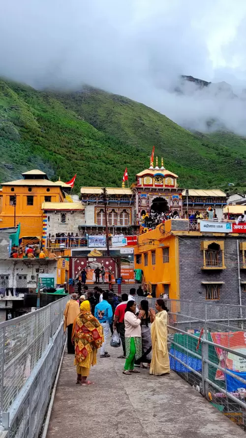 Pilgrims visiting the colorful Badrinath Temple nestled in the green Himalayan mountains of Uttarakhand, showcasing a popular destination for Uttarakhand tour packages.