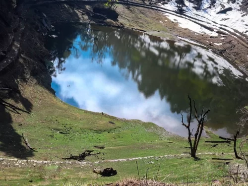 Thamri Kund Harkot near Munsiyari, Uttarakhand with a serene alpine pond reflecting surrounding forests, a scenic trekking spot included in Uttarakhand tour packages