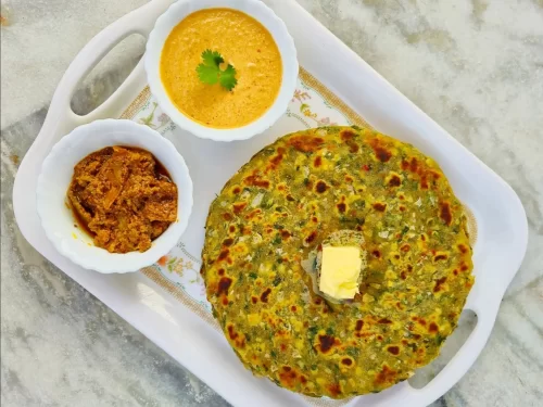 Gujarati thepla served hot with butter, chutney, and pickle, showcasing a rustic spiced flatbread meal from Gujarat.