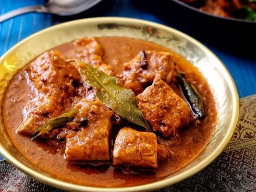 Houseboat at Alleppey backwaters during sunset, featuring palm trees and calm lagoons, romantic Kerala tour package.